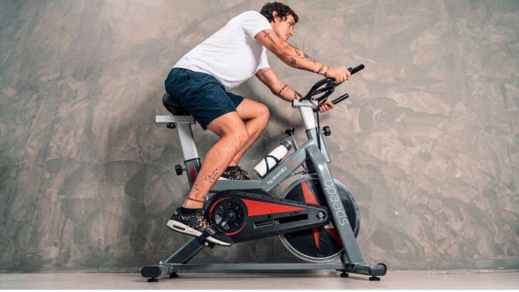 Pessoa pedalando na bicicleta Speedo S103 em treino residencial de spinning