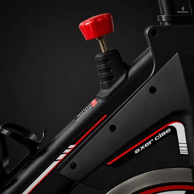 Bicicleta Spinning Evox X1 preta e vermelha vista lateral completa.