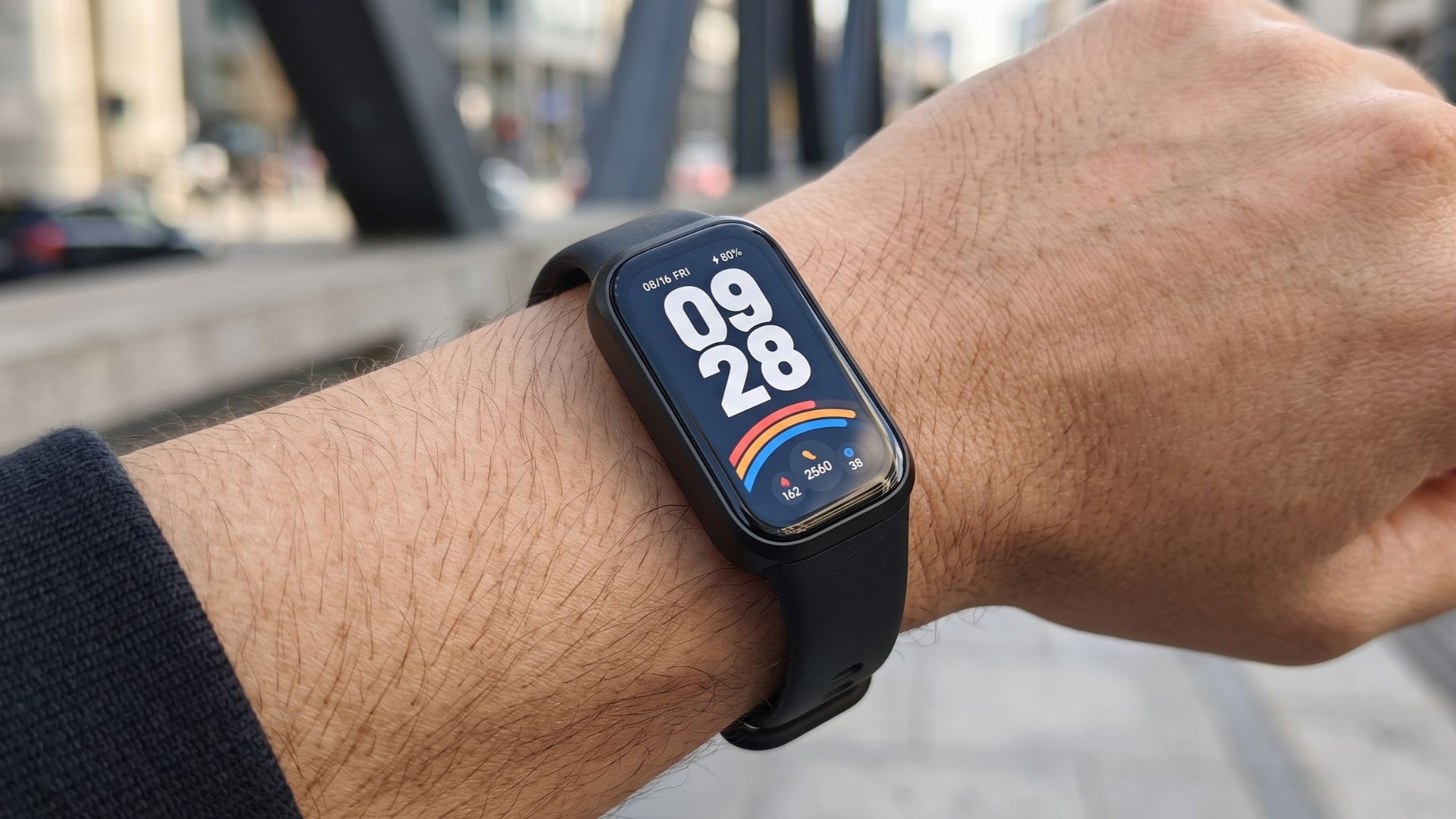 Xiaomi Smart Band 9 Active no pulso exibindo mostrador de horas e passos